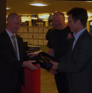 Thor Mønsted fra HP Elektronikmontage modtager prisen "Den Gyldne Loddekolbe" fra Anders Enggaard, Axcon, mens redaktør for Aktuel Elektronik, Rolf Sylvester-Hvid ser på.